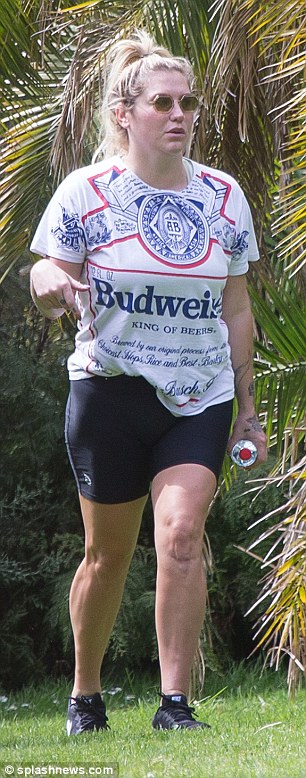 Legs eleven! The Tik Tok singer kept it casual in a Budweiser T-shirt, bike shorts and sneakers, and styled her blonde hair into a scruffy high ponytail