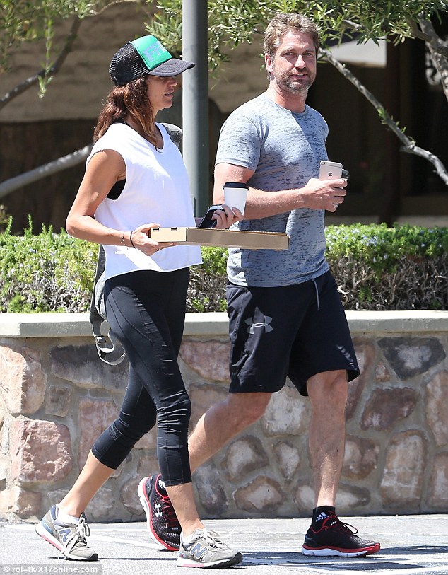 Worth it: Gerard Butler and his girlfriend Morgan Brown  stopped to collect a pizza after a particularly gruelling exercise session in Los Angeles on Friday