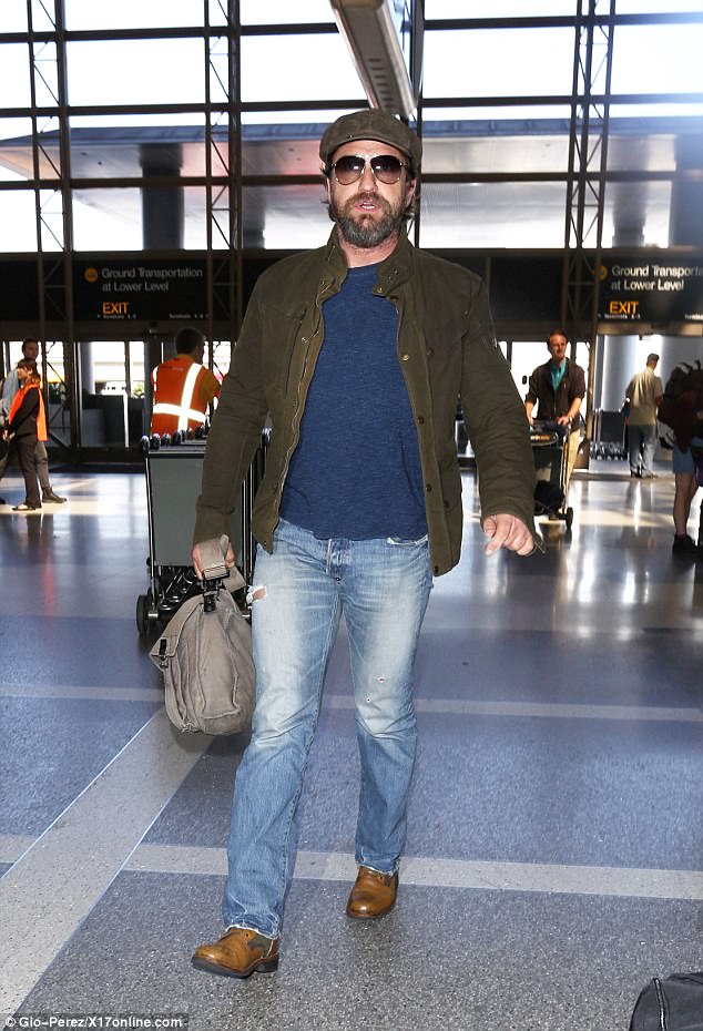 Jetting off: Gerard was still in the same ripped jeans, khaki jacket and brown footwear