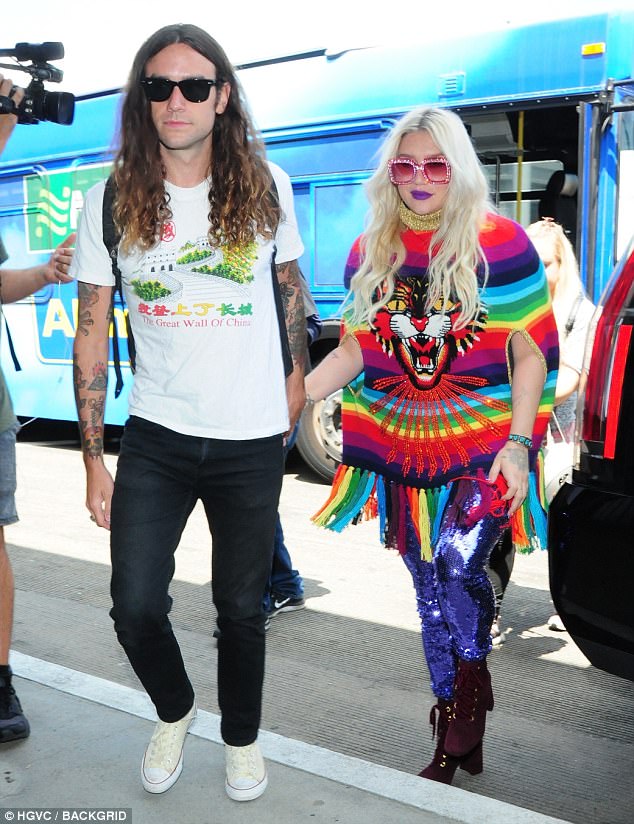 Stunner: She paired the hallucinogenic look with purple sequined leggings that were tucked in to tall brown boots