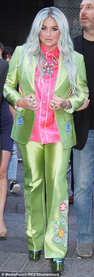 Rainbow brights: The star's shiny bell-bottomed outfit featured flowers and rainbows embellished throughout, and she wore a pair of metallic green and blue platform heels