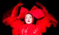 Paulina Lenoir in red dress, red gloves and red headpiece on black background