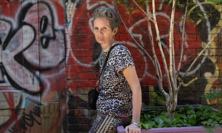 Sharon Graham poses for a picture by a colourful graffitied wall