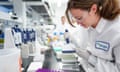 A woman uses a pipette in a laboratory