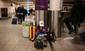 Person sat on floor at airport reading a book.