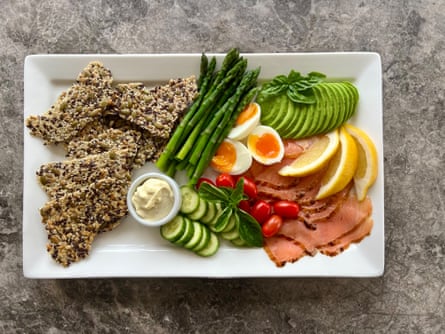 Topview of a platter with crispbread, vegetables and smoked trout
