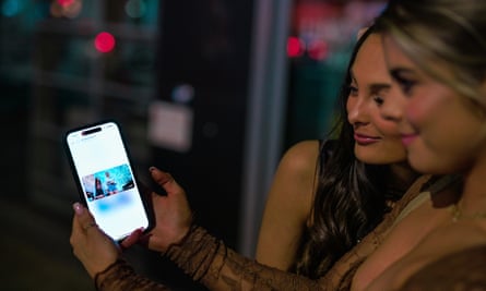 Two women look at a video on a mobile phone