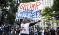 A smiling person holds a sign that reads 'Trump convicted'