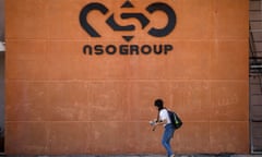 A woman walks past the entrance of an NSO Group building
