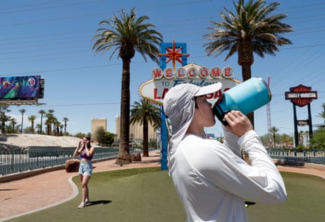 a person drinks from a large water bottle