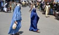 Afghan women walk along a road at a market area in Kandahar