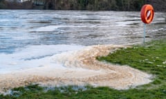 Brown sewage foams on the River Thames