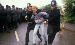 Two policeman drag away a striking miner at Orgreave, 1984