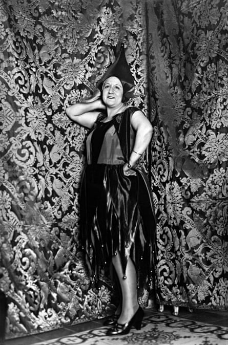 Man wearing dress posing in front of curtains, from the Album de salón y alcoba