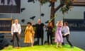 The cast stand under a tree with huge signs bearing words like Allegria, Fedelta, Comodo, Piacer