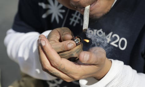 A man lights up a marijuana cigarette.