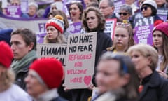 A protester holds a sign saying "no hate no fear refugees are welcome here" at a rally