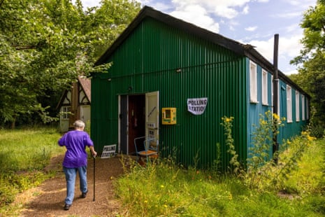 A female voter walks, with a stick, towards a polling station in Peasmarsh, East Sussex on Thursday