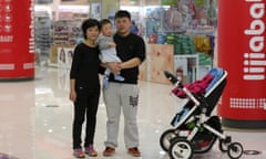 Zhao Xingqiu poses with her husband and baby in front a baby products shop in Beijing October 30, 2015. Zhao Xingqiu, 27, an office worker, said she does not plan to have a second child. When she heard about the rule change of one child policy, she thought it could not change much because there are some difficulties raising child in China. China has unwound its one-child policy, for decades a symbol of invasive and coercive government planning, but the shift has been met with a disinterested shrug from many younger couples. REUTERS/Kim Kyung-Hoon