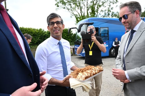 Rishi Sunak handing out a tray of bara brith after a visit to Swans farm shop.