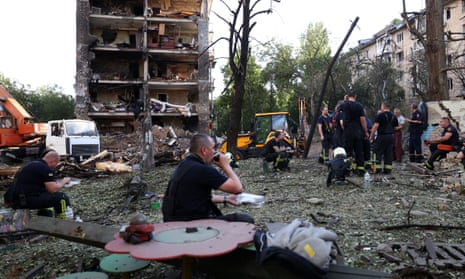 Rescuers near an apartment building and kindergarten destroyed by a missile strike in Kyiv.