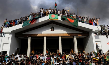 Anti-government protestors display Bangladesh’s national flag as they storm prime minister Sheikh Hasina’s palace in Dhaka on 5 August.