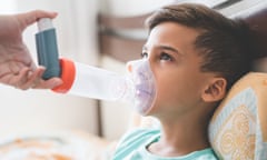 A child wearing inhaling through a mask with an inhaler attached