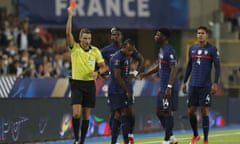 France’s Jules Koundé, centre, is shown a red card.
