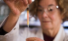 Biogeochemistry lab manager Janet Hope from the ANU research school of earth sciences holds a vial of coloured porphyrins (pink coloured liquid), believed to be some of the oldest pigments in the world.