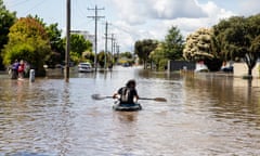 A local resident paddles through a flooded street in Shepparton, Victoria on Sunday.