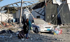 A woman salvages her belongings after the airstrike