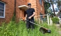 Nathan Stafford holds a whipper snipper in an overgrown garden