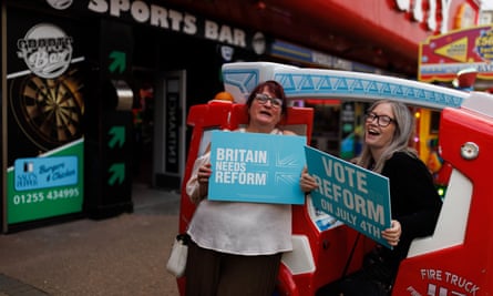 Two women holding Reform placards outside an amusement arcade on June 18, 2024 in Clacton-on-Sea.