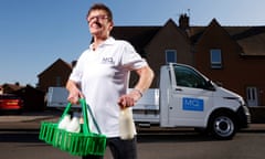 Milk deliverer Davina Bruce, holding milk bottles and standing in front of her van