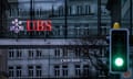 A traffic light signals green in front of the logos of the Swiss banks Credit Suisse and UBS in Zurich, Switzerland