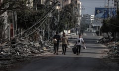 People walk amid debris after Israeli airstrikes hit Tel al-Hawa, the western Gaza City on Monday.