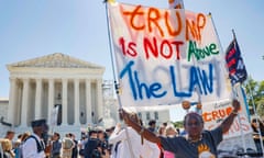 people holding signs stand in front of white building with columns