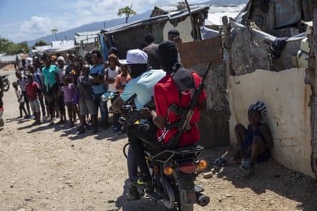 G9 coalition gang members ride a motorcycle through the Wharf Jeremy street market in Port-au-Prince, Haiti, in October 2021.