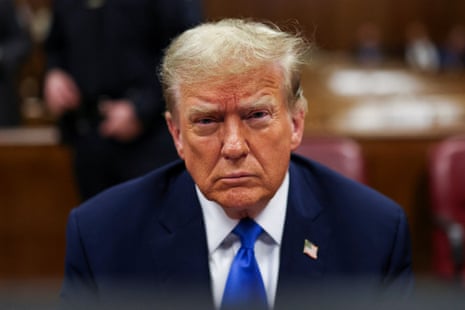 a man in a dark blue suit and bright blue tie frowns