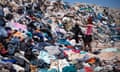 A woman searches through tons of used clothes in the Atacama desert in Chile