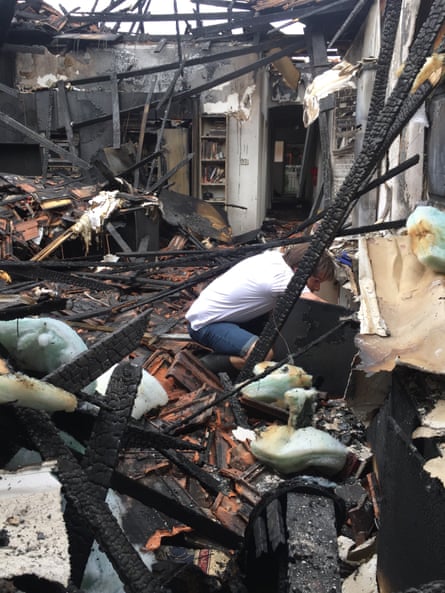 Matt Herbert searches through the remains of his house which burnt down before Christmas.