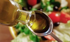 Olive oil being poured on to a spoon