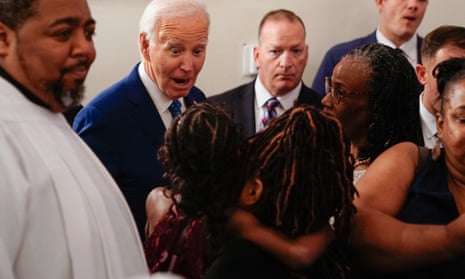 man wearing suit speaks to person holding child