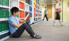 Chinese man reading book in library