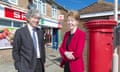 Tim Parker pictured in a grey suit and white shirt with Paula Vennells dressed in a red jacket next to a red post office box outside a branch in Sussex