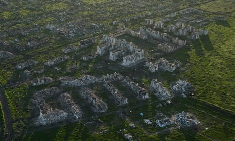 An aerial photograph of Maryinka, showing  a cluster of bombed out buildings surrounded by green fields. 