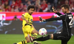 Dortmund’s Karim Adeyemi slides the ball past Sven Ulreich in the Bayern Munich goal.