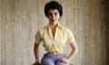 A woman poses for the camera wearing a yellow blouse and purple trousers