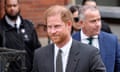 Head and shoulders shot of Prince Harry with people behind him