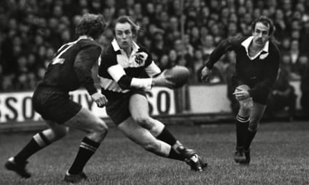 Duckham, centre, dummies Ian Hurst, left, during the classic 1973 Barbarians match against New Zealand in Cardiff, which the Barbarians won 23-11.